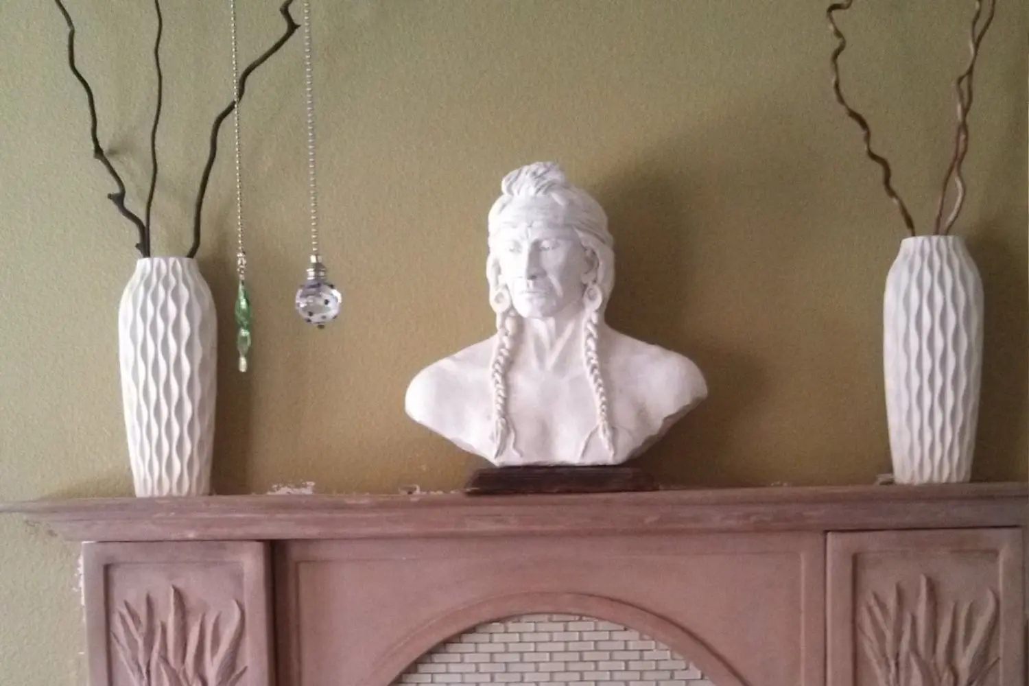 Bust with vases on a mantelpiece.