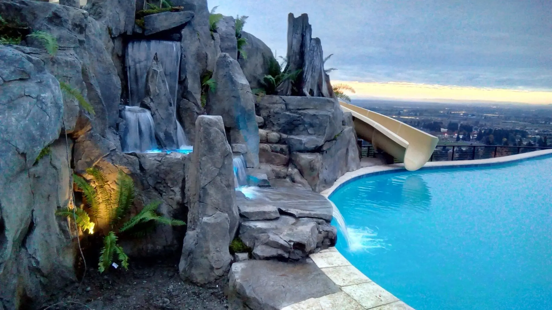 Rock waterfall and slide by infinity pool.