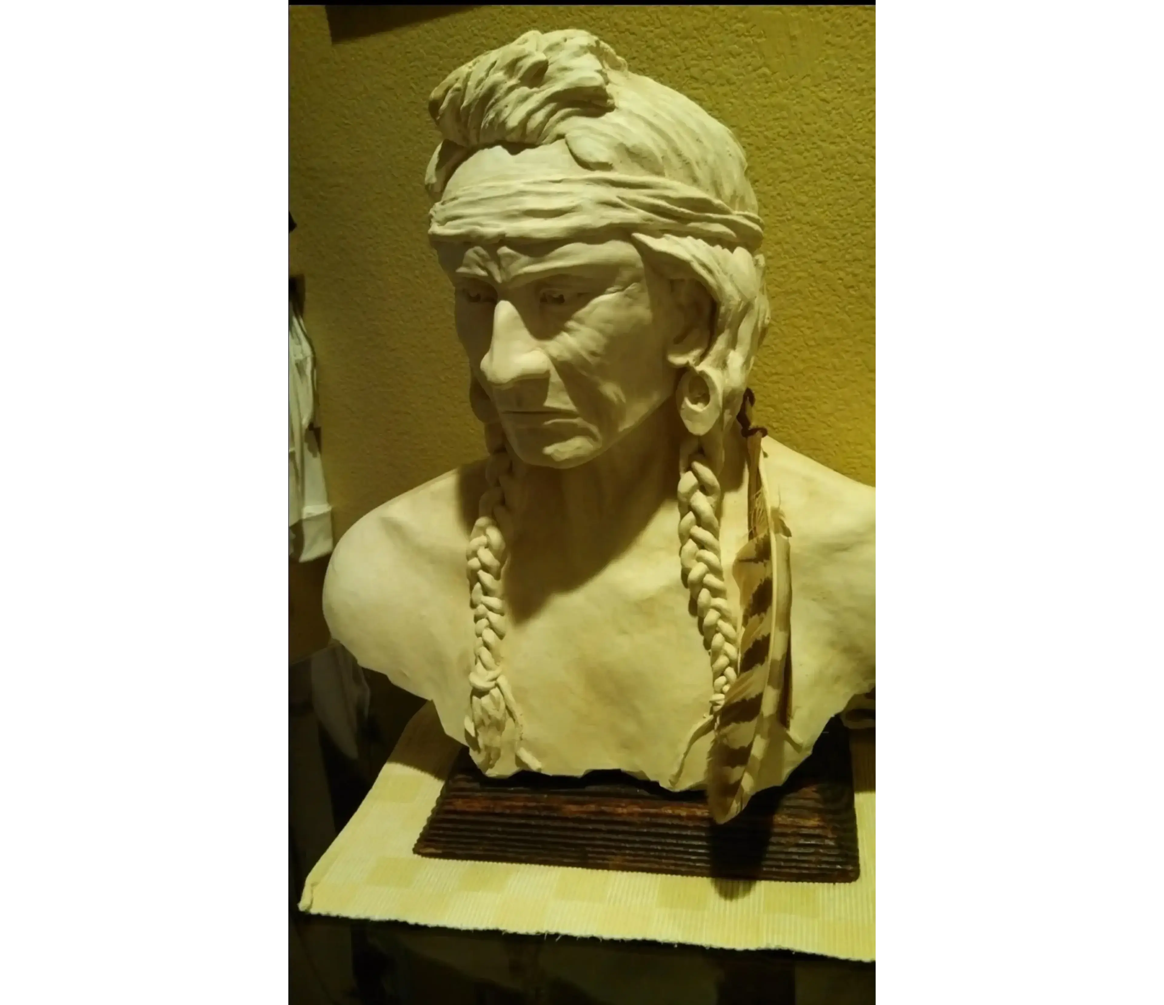 Bust sculpture of a person with braids.