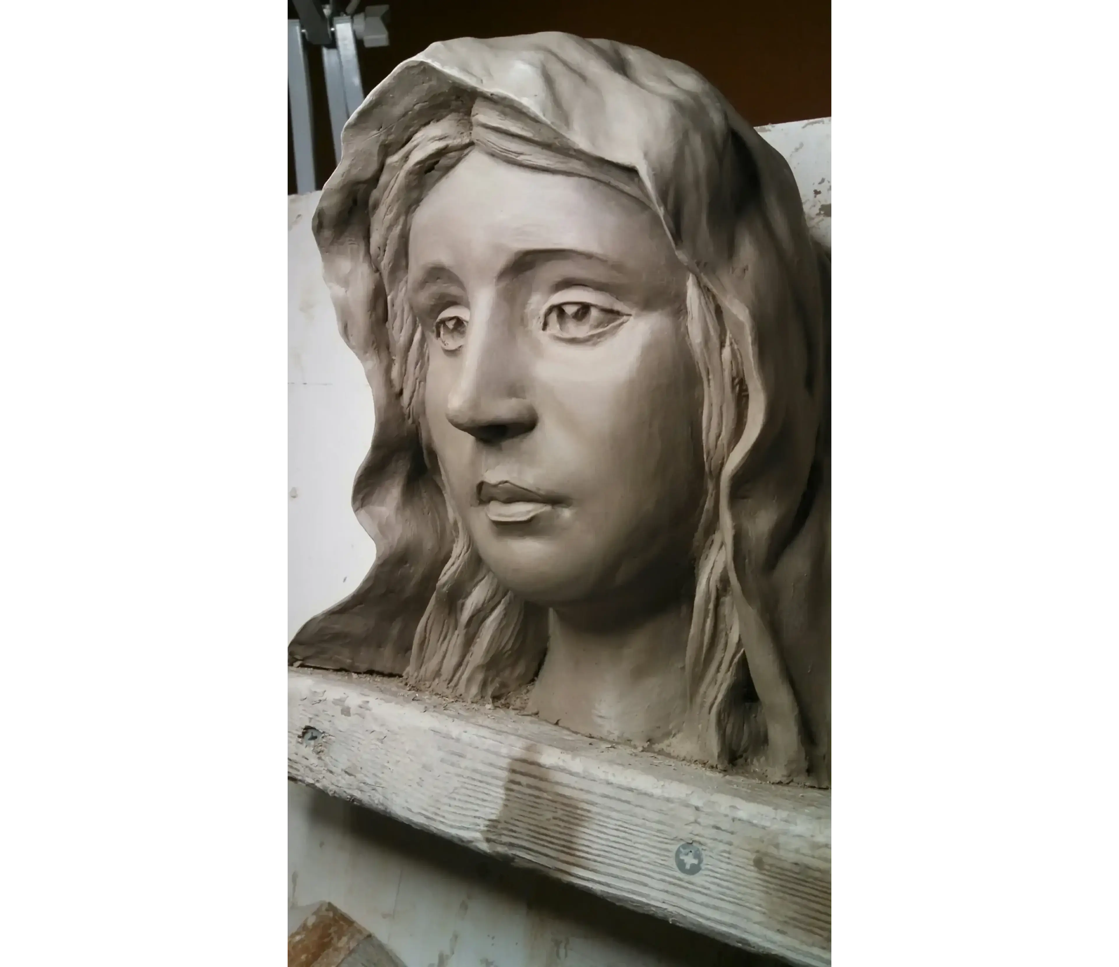 Clay sculpture of a woman's head.